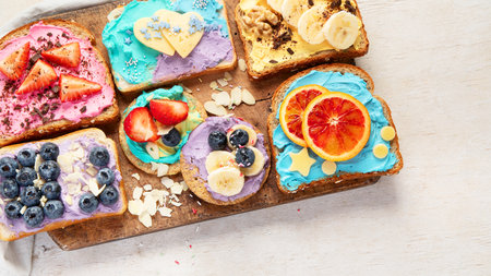 Sweet breakfast. Colorful toasts with fruits and berries. Children's food concept. Top viewの写真素材