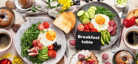 Breakfast served with coffee, fresh bakery, eggs, salad, meat and fruits. Holiday concept. Top view.の写真素材