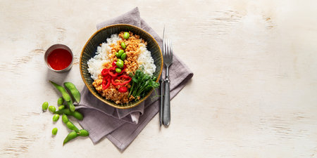 Vegan food. Soy meat, white rice, beans, red pepper on light wooden background. Top view, copy space, bannerの写真素材