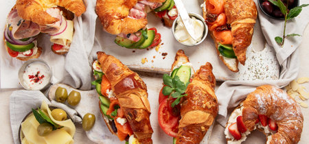 Set of tasty sweet and salty croissant sandwiches on white background, top view. Panorama.の写真素材