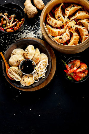 Chinese dumplings, soy sauce, mushrooms on dark background. traditional asian food concept. Top view, copy spaceの写真素材