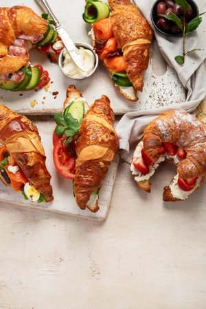 Set of tasty sweet and salty croissant sandwiches on white background, top view. Copy space.の写真素材