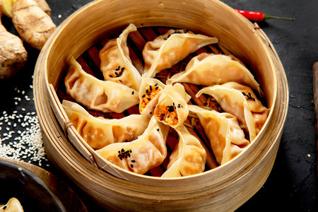 Chinese dumplings, soy sauce, mushrooms on dark background. traditional asian food concept.の写真素材