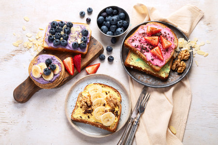 Sweet toast assortment. Banana, cream cheese, peanut butter and strawberry, cream cheese and blueberry on a white background. Top view.の写真素材