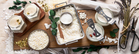 DIY. Crafting white aroma candles on light wood background. Top view, bannerの写真素材