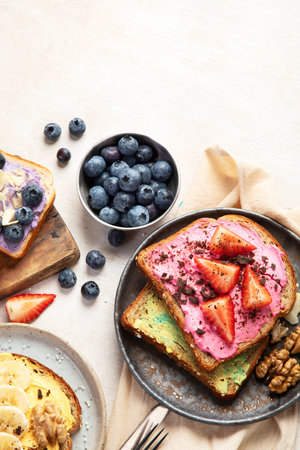 Sweet toast assortment. Banana, cream cheese, peanut butter and strawberry, cream cheese and blueberry on a white background. Top view. Copy space.の写真素材