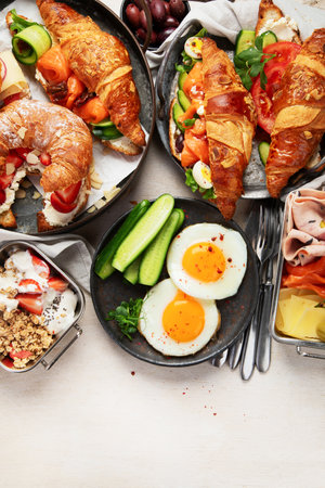 Breakfast served with coffee, croissants, eggs and snacks on a white background. Balanced diet. Top view.の写真素材