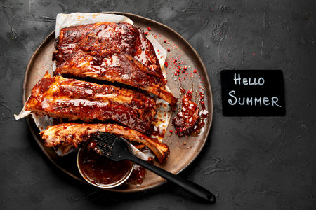 Hot grilled spare ribs from a summer BBQ served on a plate with sauce. Top view.の写真素材