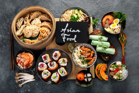 Assorted Chinese food set. Chinese noodles, fried rice, dumplings, dim sum, spring rolls. Famous Chinese cuisine dishes on a black background. Top view.の写真素材