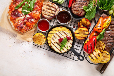Grilletables and meat. Cooked steak, corn, pepper, peach on light background. Food concept. Top viewの写真素材