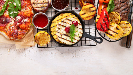 Grilletables and meat. Cooked steak, corn, pepper, peach on light background. Food concept. Top...