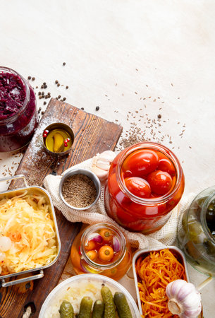 Fermented products on a wooden background. Pickled vegetables in jars. Top view, copy spaceの写真素材