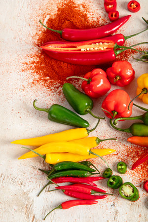 Colorful raw peppers on a light wooden background. Delicious vegetables concept. Top view