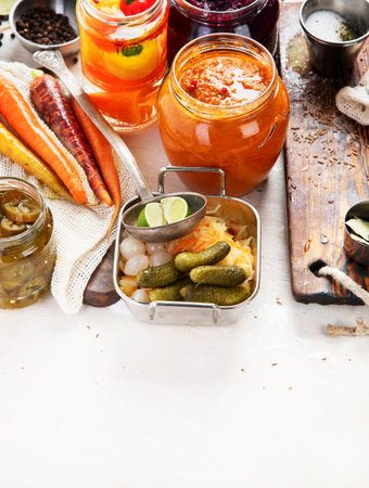Fermented products on a wooden background. Pickled vegetables in jars. Top view, copy spaceの写真素材