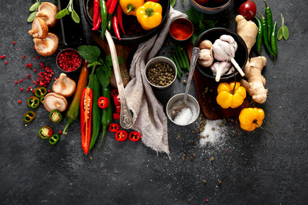 Spices, peppers, garlik, tomatoes, mushrooms on dark background. Ingredient for cooking. Top view, copy spaceの写真素材