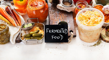 Fermented products on a wooden background. Pickled vegetables in jars. Top viewの写真素材
