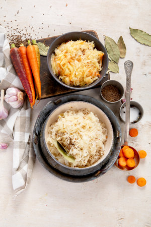 Winter salad on wooden light background. Homemade sauerkraut cabbage with carrot. Tasty food. Top viewの写真素材