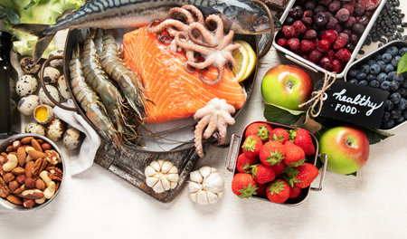 Healthy food selection on light background. Detox and clean diet concept. Foods high in vitamins, minerals and antioxidants. Anti age foods. Top view, panorama with copy space.の写真素材