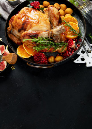 Concept of Christmas or New Year dinner with roasted chicken and various appetizers on a dark background. Top view. Copy space.の写真素材