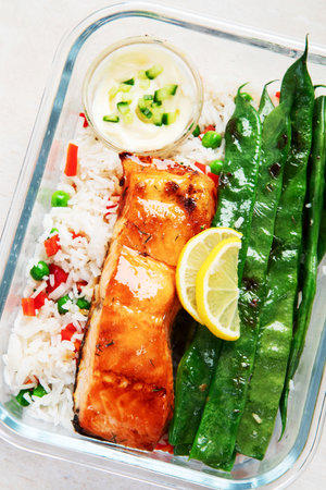 Salmon with rice and vegetables in a glass containers made for meal prep on a light background, top view. Healthy lifestyle.の写真素材