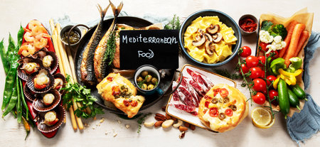 Assortment various Mediterranean food - fish, shrimp, seafood, ravioli, vegetables on a white background. Top view. Panorama.の写真素材