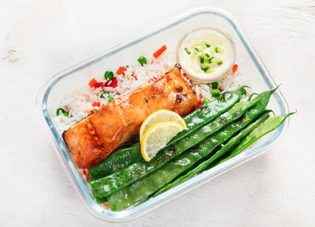 Salmon with rice and vegetables in a glass containers made for meal prep on a light background, top view. Healthy lifestyle.の写真素材