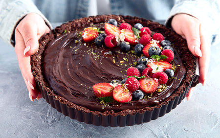 Young woman holding homemade chocolate tartの写真素材