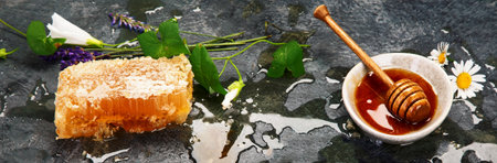 Honeycomb and honey in bowl on dark background. Organic food concept.の写真素材