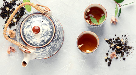 Asian teapot with herbal tea. Plant leaves, natural herbal tea composition. Top view, flat lay, copy spaceの写真素材