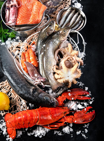 Fresh fish and seafood on black background, fish market. Healthy diet eating concept. Top viewの写真素材