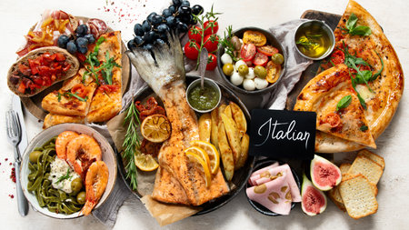 Full table of Italian meals on plates and board - Pizza, pasta, salami, parmesan, olives, bread sticks on a white background. Top view.の写真素材