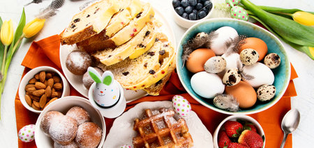 Festive Easter table setting. Natural colorful eggs and spring flowers rustic composition. Top view.の写真素材