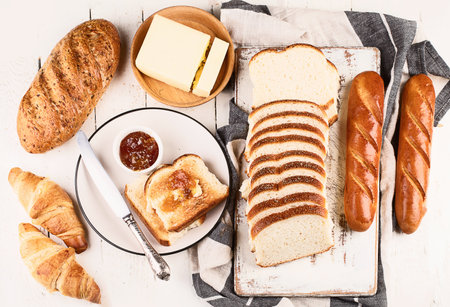 Cutting board with toast bread, jam and butterの写真素材
