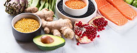 Selection of healthy food. Clean eating concept. Cooking ingredients with fish, superfood, vegetables, artichokes, Brussels sprouts, fruits, legumes. Top view. Panorama.の写真素材
