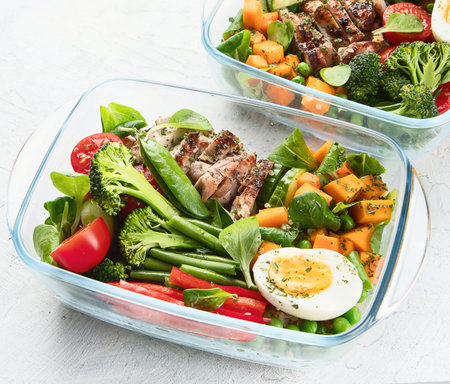 Healthy lunch box with chicken, quinoa and vegetables in boxes. Balanced diet eating concept. Top view.の写真素材