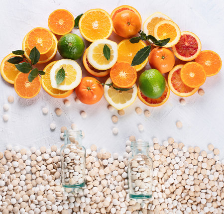 Colorful of citrus fruits and vitamin pills on a white background. Healthy lifestyle concept. Top view.の写真素材