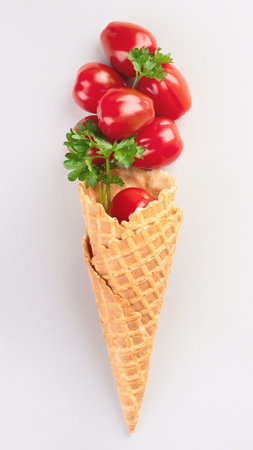 Healthy fresh tomatoes in waffle cones on a gray background. Vegan and vegetarian diet concept. Healthy eating. Top view.の写真素材