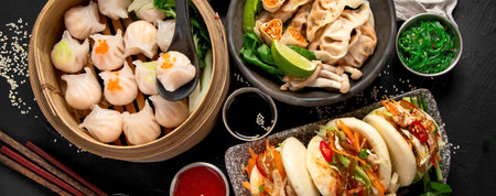 Chinese dumplings, soy sauce, dim sum on a dark background. Traditional Asian food concept. Top view. Panorama.の写真素材