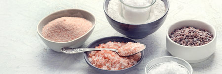 Assortment of salt types on gray background. Top view. Panorama with copy space.の写真素材