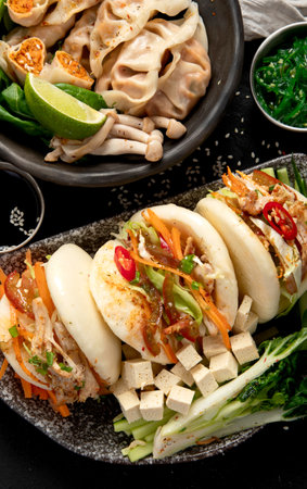 Dumplings, soy sauce, dim sum on a dark background. Traditional Asian food concept. Top view. Copy space.の写真素材
