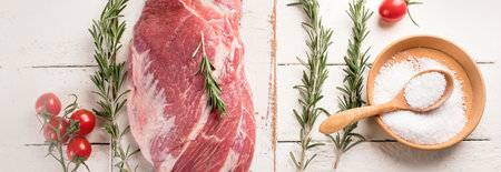 Raw pork meat with herb and salt on a white wooden background. Top view. Panorama.の写真素材