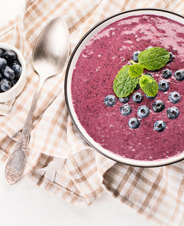 Smoothie bowl with fresh blueberries for healthy breakfast on a white background. Top view. Copy sapce.の写真素材
