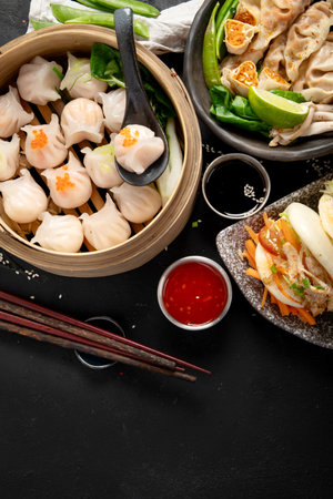 Chinese dumplings, soy sauce, dim sum on a dark background. Traditional Asian food concept. Top view. Copy space.の写真素材