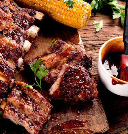 Pork ribs with corn on a wooden board. American food concept. Top view.の写真素材