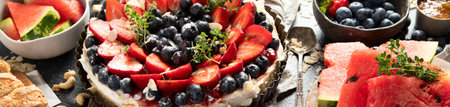 Homemade Strawberry and Blueberry tart with watermelon and jam for dessert on a gray background. Top view. Panorama, banner.の写真素材