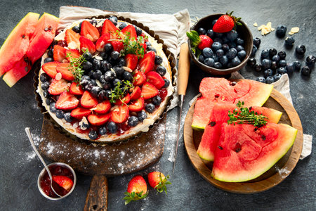 Delicious tart with fresh strawberries and blackberries on a gray background. Top view.の写真素材