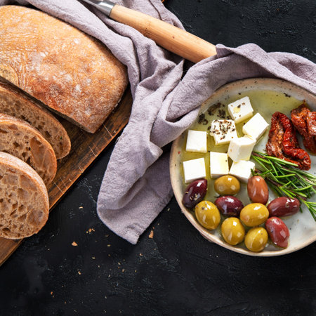 Olives, olive oil and ciabatta bread on dark background. Top view.の写真素材