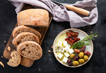 Olives, olive oil and ciabatta bread on dark background. Top view.の写真素材