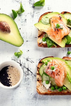 Healthy spring toasts with avocado and salmon. Healthy breakfast concept. Top view.の写真素材