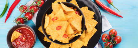 Mexican nachos on a blue background. Chilli corn chips. Top view. Panorama.の写真素材